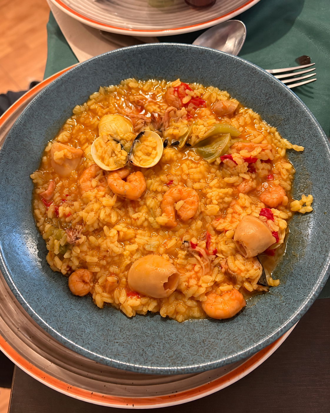 Arroz con marisco servido en un cuenco de cerámica oscuro en Edén