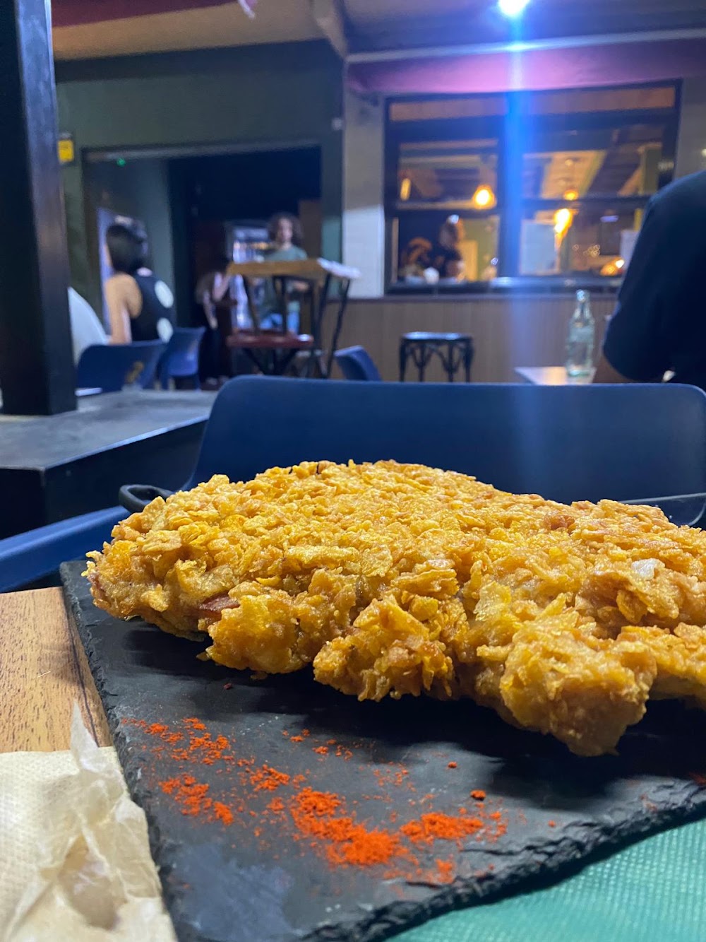 Cachopo dorado con rebozado crujiente sobre una pizarra