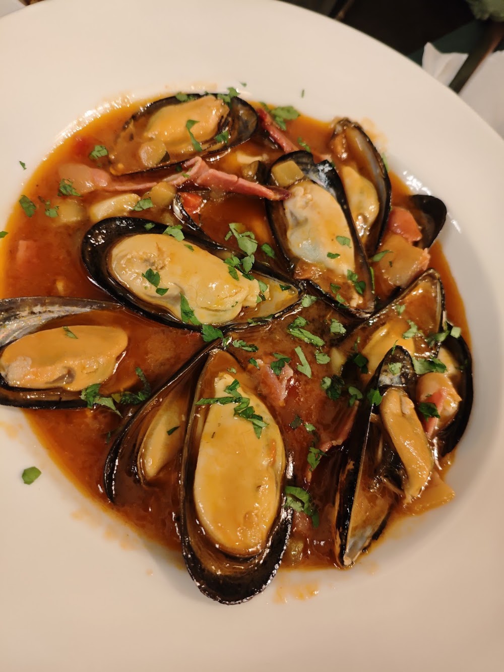 Mejillones abiertos servidos con la salsa de la casa
